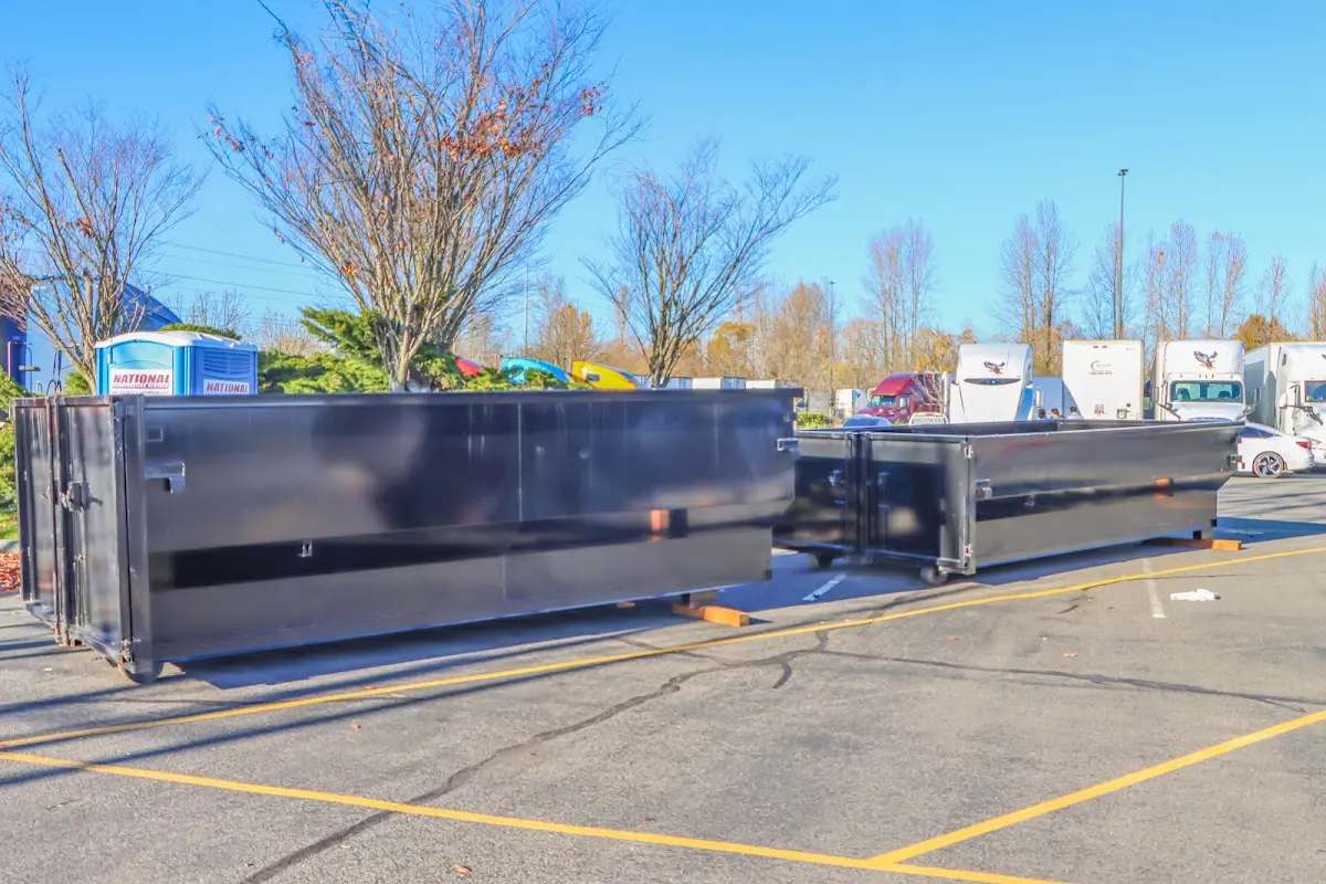 Professional dumpster rental service with roll-off container on residential driveway in Lawrence